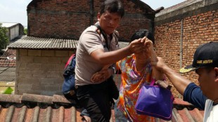 Kapolsek Jati Asih, Kompol Aslan, membantu warga yang terjebak banjir menaiki perahu karet (dok. KM)