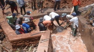 Warga Cibunian sedang berusaha mengangkat batu yang jatuh menutupi waterway akibat longsor yang melanda pada Minggu 3/4 lalu (dok. KM)