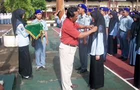 Wawan Gunawan, Kepala sekolah di SMK Bina Nusantara Cilaku, Cianjur, sedang menyematkan pin pada salah satu siswa nya. (dok. KM)