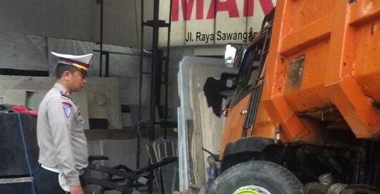 Polisi mengamati kondisi truk yang menghantam toko marmer di Sawangan, Depok, Selasa dini hari (17/5) (dok. km)
