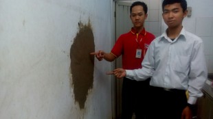 Pegawai Alfamart menunjukkan bekas lubang di tembok akibat pembobolan oleh maling (dok. KM)