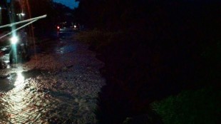 Tampak jalan amblas di depan gerbang masuk perumahan Lido Permai, Bogor, setelah longsor pada Kamis sore (16/6)