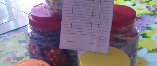 5 toples permen beserta nota kontan polos yang diberikan oleh terduga pelaku penipuan dengan modus iming-iming terhadap pemilik warung (dok. KM)