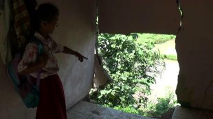 Seorang siswi SDN Tegal 4 Kemang menunjukkan kios warga sebelah sekolah yang sudah roboh sebagian akibat longsor (dok. KM)
