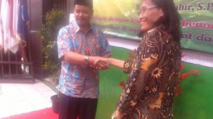 Kepala sekolah baru SDN Cisalak Pasar 1 Juwahir berjabat tangan dengan kepsek lama Emirita Sukarmi pada acara lepas sambut kepala sekolah, Jumat 26/8 (dok. KM)