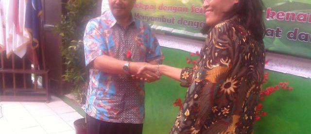 Kepala sekolah baru SDN Cisalak Pasar 1 Juwahir berjabat tangan dengan kepsek lama Emirita Sukarmi pada acara lepas sambut kepala sekolah, Jumat 26/8 (dok. KM)