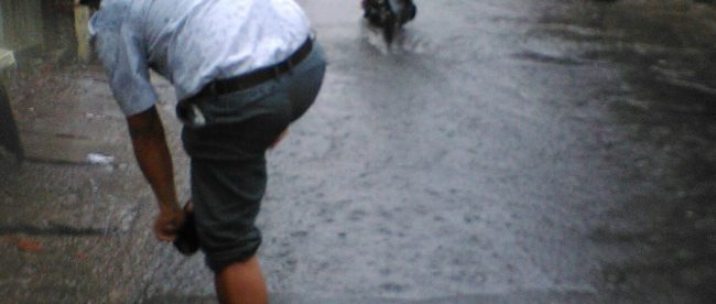 Warga harus melintasi jalanan yang tergenang menyusul hujan yang mengguyur Jakarta (dok. KM)