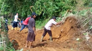 Warga membersihkan jalan desa dari tanah yang menutupi setelah kejadian tanah longsor di desa Cibunian, Pamijahan (dok. KM)