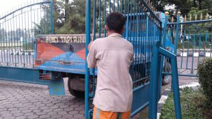 Pintu gerbang Gedung DPRD ringsek dan dipegang salah satu warga agar tidak rubuh (dok. Irfan/KM)