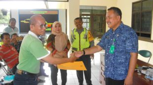 Lurah Tengah Kec. Cibinong (kanan) menyerahkan secara simbolis SK pengangkatan Ketua RT/RW dan memberikan insentif operasional bulanan. (dok. KM)
