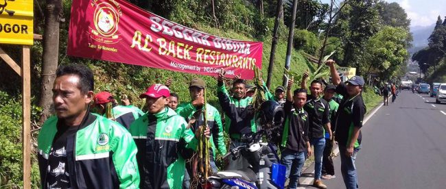 Komunitas Pramu Wisata Puncak dalam aksi tanam bunga hiasnya di Jalan Raya Puncak, Selasa 18/4 (dok. KM)