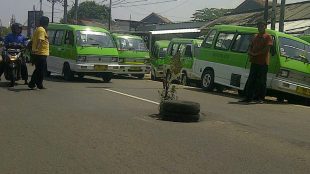 Warga menaruh band dan ranting phon di tengah jalan untuk menandai lubang lebar dan dalam yang kerap memakan korban di Salabenda, Bogor (dok. KM)