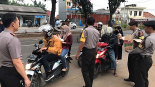 Sejumlah petugas kepolisian dari Polsek Cileungsi bagi-bagi takjil kepada pengguna jalan di Cileungsi, Kabupaten Bogor (dok. KM)