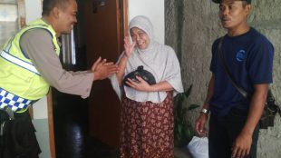 Anggota Bhabinmas Polsek Dramaga memberikan bantuan 2 liter beras kepada jompo dari hasil program Toples Receh Peduli (dok. KM)
