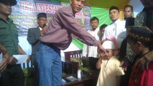 Ketua LSM PRMDC,Lukman, saat membagikan santunan kepada anak yatim di panggung acara, Rabu 21/6 (dok. KM)