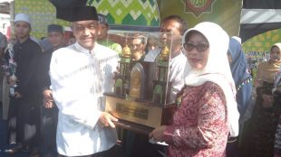 Camat Pondok Melati Ika Indah Yanti menerima piala bergilir sebagai juara umum MTQ Kota Bekasi dari Wakil Walikota Bekasi Ahmad Syaikhu (dok. KM)