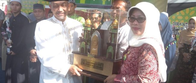 Camat Pondok Melati Ika Indah Yanti menerima piala bergilir sebagai juara umum MTQ Kota Bekasi dari Wakil Walikota Bekasi Ahmad Syaikhu (dok. KM)