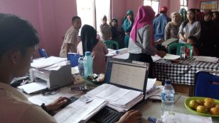 Warga desa Pasirjaya, Kecamatan Cigombong, memperbaiki berkas pengajuan untuk pembuatan akte kelahiran di Kantor Desa, Kamis 3/8 (dok. KM)
