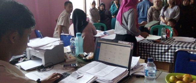 Warga desa Pasirjaya, Kecamatan Cigombong, memperbaiki berkas pengajuan untuk pembuatan akte kelahiran di Kantor Desa, Kamis 3/8 (dok. KM)