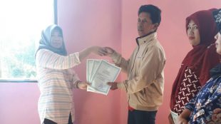 Warga Desa Pasir Jaya, Kecamatan Cigombong, menerima Akta Kelahiran yang sudah selesai dibuat oleh pihak Disdukcapil Kabupaten Bogor, Sabtu 5/8 (dok. KM)