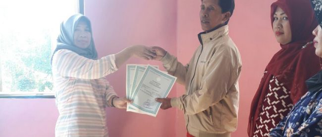 Warga Desa Pasir Jaya, Kecamatan Cigombong, menerima Akta Kelahiran yang sudah selesai dibuat oleh pihak Disdukcapil Kabupaten Bogor, Sabtu 5/8 (dok. KM)