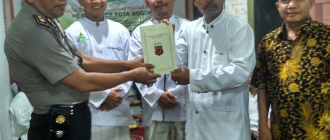 Polisi menyerahkan bantuan dari Kapolresta Bogor Kota untuk pembangunan majelis Riyadlul Shalawat, Kamis 3/8 (dok. KM)