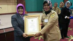 Bupati Bogor Nurhayanti memberikan penghargan Desa Lunas PBB kepada Kades Kalong I, Kecamatan Leuwisadeng, Yenih Permana (dok. KM)