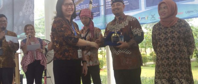 Wakil Rektor UMN Bidang Kemahasiswaan, Ika, saat memberikan plakat kepada kepala Anjungan Provinsi Jambi Amrusyah (dok. KM)