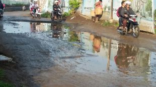 Warga melintasi jalan rusak di wilayah Kabupaten Bogor (KM Stock)