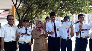 Siswa SMPN 22 Depok dan Guru Pembina Memperlihatkan medali Taekwondo yang diraih (dok. KM)