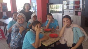 Koordinator kantin sekolah Tunas Global Nurmainim (baju hitam) bersama para siswa di kantin sekolah (dok. KM)