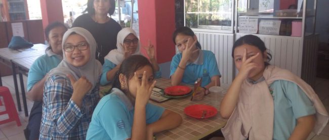 Koordinator kantin sekolah Tunas Global Nurmainim (baju hitam) bersama para siswa di kantin sekolah (dok. KM)