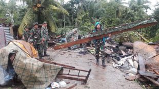 Prajurit membantu mengumpulkan puing-puing bangunan setelah peristiwa angin puting beliung di Aceh Utara, Minggu 26/11 (dok. KM)