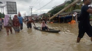 Seorang ibu yang mengalami sakit dievakuasi pihak relawan ke tempat yang lebih aman di depan Kantor Polsek Lhoksukon, Senin 4/12 (dok. Raz/KM)