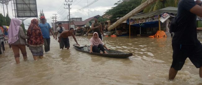 Seorang ibu yang mengalami sakit dievakuasi pihak relawan ke tempat yang lebih aman di depan Kantor Polsek Lhoksukon, Senin 4/12 (dok. Raz/KM)