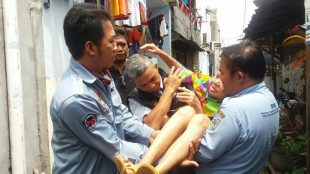 Petugas Dinas Sosial DKI mengangkat Kimyati (75), nenek yang telantar dan hidup sendirian (dok. KM)