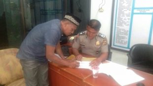 Burhanuddin sedang mendatangani Surat Tanda Terima Laporan di Kantor Propam Polda Aceh, Rabu 20/12/2017 (dok. KM)