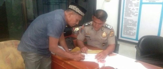 Burhanuddin sedang mendatangani Surat Tanda Terima Laporan di Kantor Propam Polda Aceh, Rabu 20/12/2017 (dok. KM)