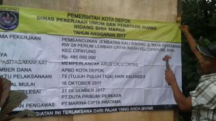 Pelaksana memasang papan proyek di lokasi pembangunan Jembatan Kali Binong, Depok, 10/12 (dok. KM)