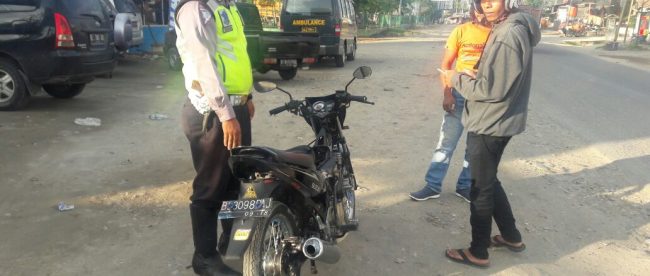 POlisi menilang pemotor yang melepas mika lampu remnya (dok. KM)