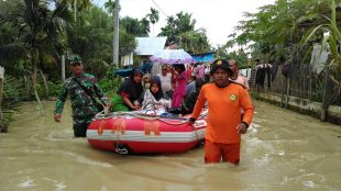 Personil dari TNI dan SAR mengevakuasi Nurmasita, ibu yang baru melahirkan anak yang terjebak banjir di Aceh Utara, Minggu 3/12 (dok. KM)