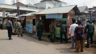 Teks Photo : Para petugas dari unsur Muspika Kecamatan Tanah Jambo Aye Aceh Utara, saat membongkar kios pedagang di Jalan Pln samping terminal bus, Kamis 11/1 (dok. Raz/KM)