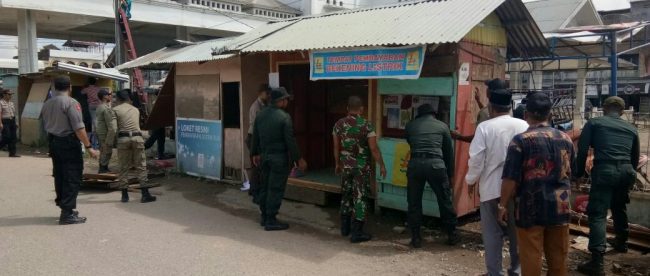 Teks Photo : Para petugas dari unsur Muspika Kecamatan Tanah Jambo Aye Aceh Utara, saat membongkar kios pedagang di Jalan Pln samping terminal bus, Kamis 11/1 (dok. Raz/KM)