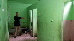 Ketua Komite SDN 03 Bojong Gede menunjukkan lokasi prasarana kamar mandi yang tidak berpintu (dok. KM)