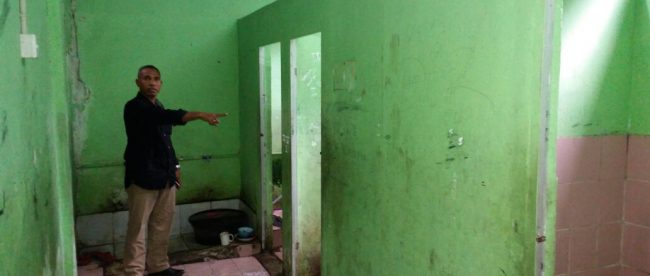 Ketua Komite SDN 03 Bojong Gede menunjukkan lokasi prasarana kamar mandi yang tidak berpintu (dok. KM)