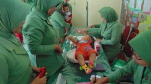 Ketua Persit KCK Cab. XX Dim 0103, Ny Eka Fadjar Wahyudi Broto, saat memberikan Makanan Tambahan serta pemberian obat cacing secara rutin bertempat di Kantor Persit Makodim setempat. Selasa 06/02/2018 (dok. Ist/Raz/KM)