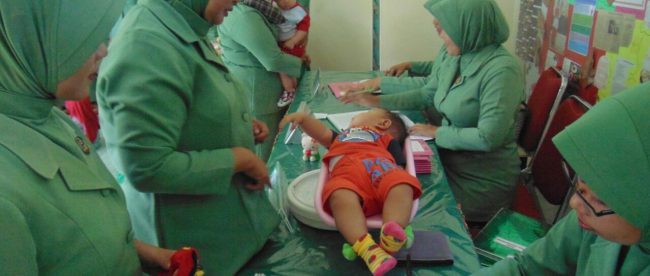 Ketua Persit KCK Cab. XX Dim 0103, Ny Eka Fadjar Wahyudi Broto, saat memberikan Makanan Tambahan serta pemberian obat cacing secara rutin bertempat di Kantor Persit Makodim setempat. Selasa 06/02/2018 (dok. Ist/Raz/KM)