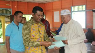 Kepala BPN Langsa menyerahkan sertifikat tanah kepada warga Gampong Buket Metuah, Sabtu 17/3 (dok. KM)