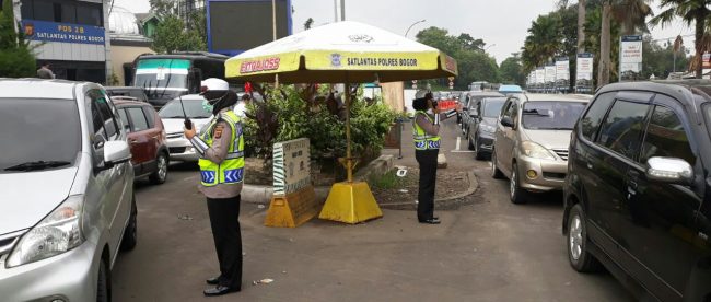 Petugas kepolisian mengatur lalu lintas di peraimpangan menuju jalur Puncak, Bogor 14/4/2018 (dok. KM)