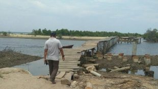 Warga sedang melintasi Jembatan Kuala Parek, Kecamatan Sungai Raya, Aceh Timur beberapa waktu yang lalu (dok. KM)